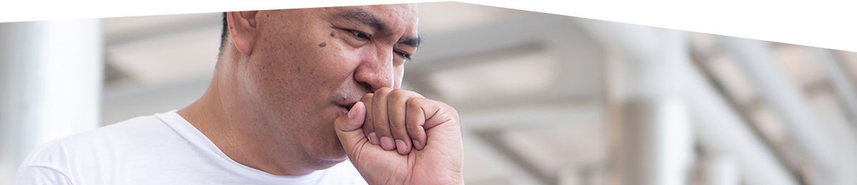 Middle-aged man coughing into his hand