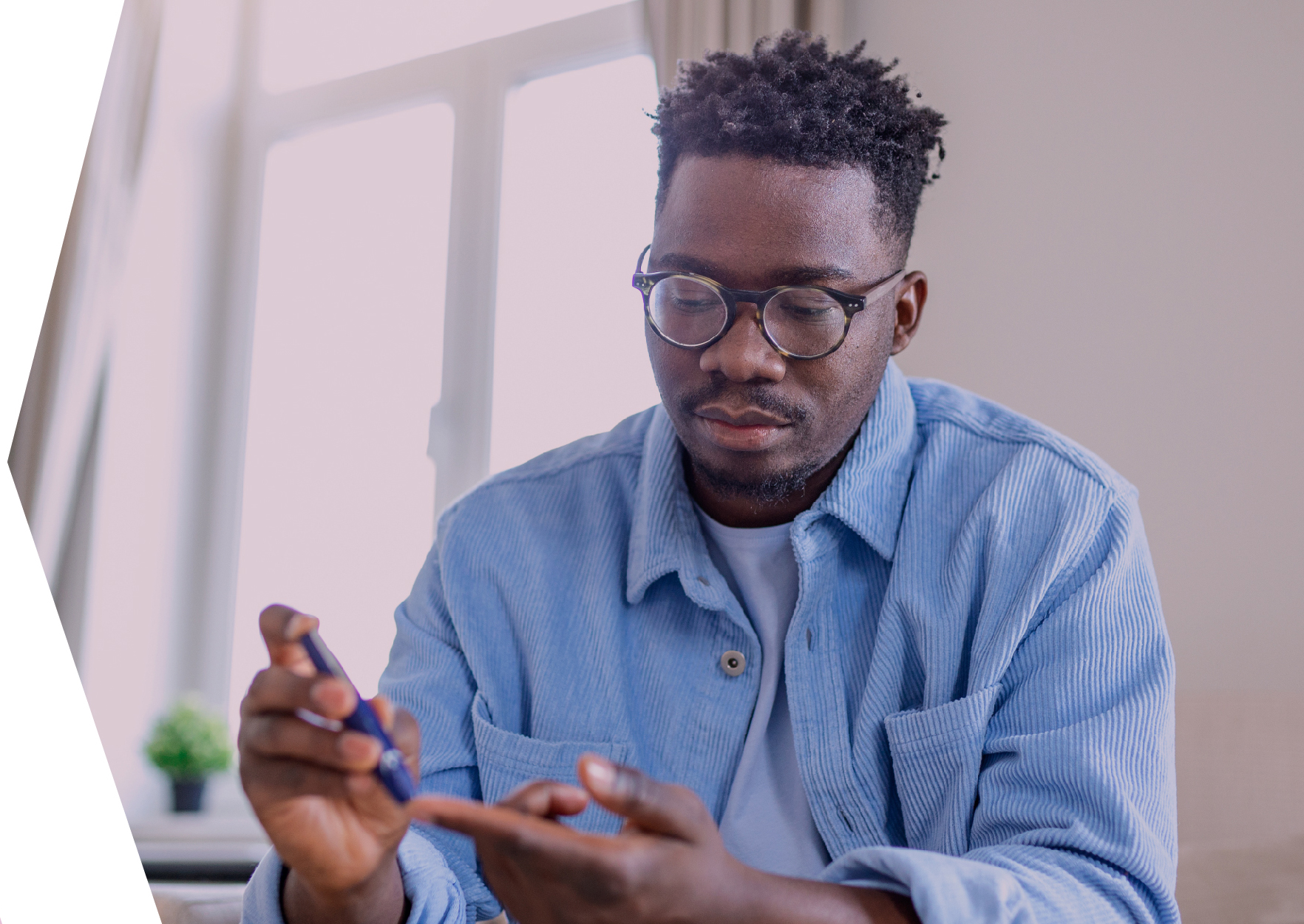 Young man testing blood sugar levels using a finger tip testing device