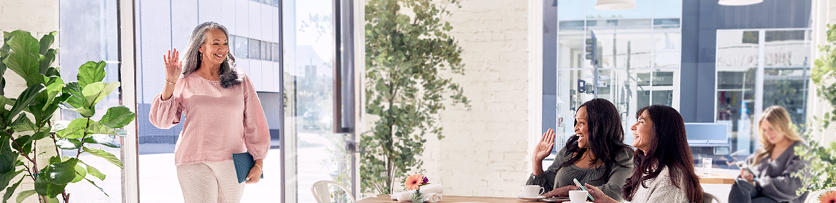 Middle-aged women waving at each other