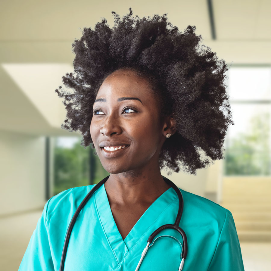 Young female healthcare professional wearing turquoise scrubs standing in a large modern foyer.